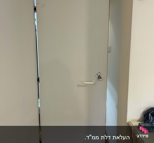דלת לבנה פתוחה עם ידית ומנעול תלוי